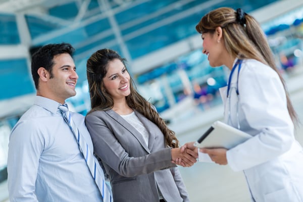 Doctor handshaking with a couple at the hospital