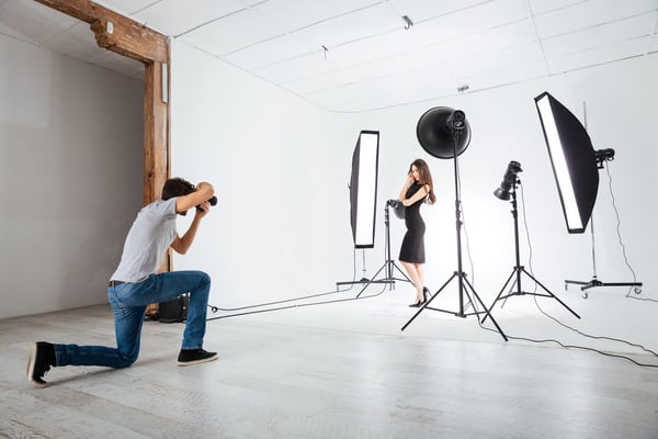 Photographer working with model in studio with equipments